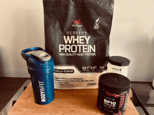 Eiwitpoeder van XXL Nutrition en Body & Fit met shaker op aanrecht